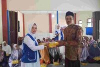 Wakil Ketua I IWAPI Kabupaten Ciamis, Hj. Rita Sumirat tengah membagikan makanan bergizi gratis.
