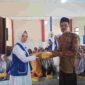 Wakil Ketua I IWAPI Kabupaten Ciamis, Hj. Rita Sumirat tengah membagikan makanan bergizi gratis.