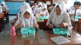 Siswa SMPN 2 ciamis tengah menikmati makan bergizi gratis.