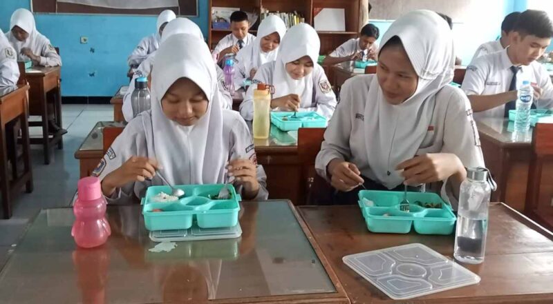 Siswa SMPN 2 ciamis tengah menikmati makan bergizi gratis.