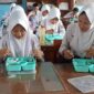 Siswa SMPN 2 ciamis tengah menikmati makan bergizi gratis.