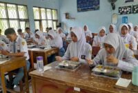 Siswa-siswi SMAN 1 Ciamis tengah menikmati makan siang dari program MBG.