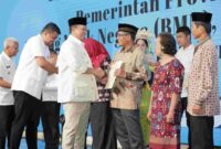 Menteri ATR/BPN, Nusron Wahid tengah menyerahkan sertipikat tanah kepada warga.