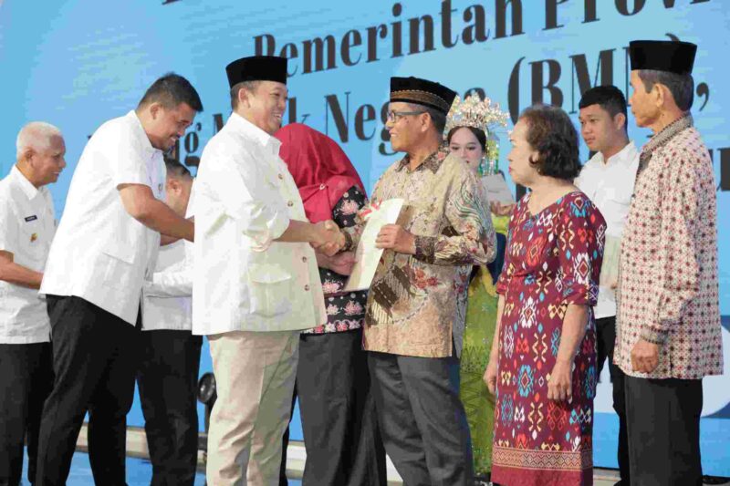 Menteri ATR/BPN, Nusron Wahid tengah menyerahkan sertipikat tanah kepada warga.